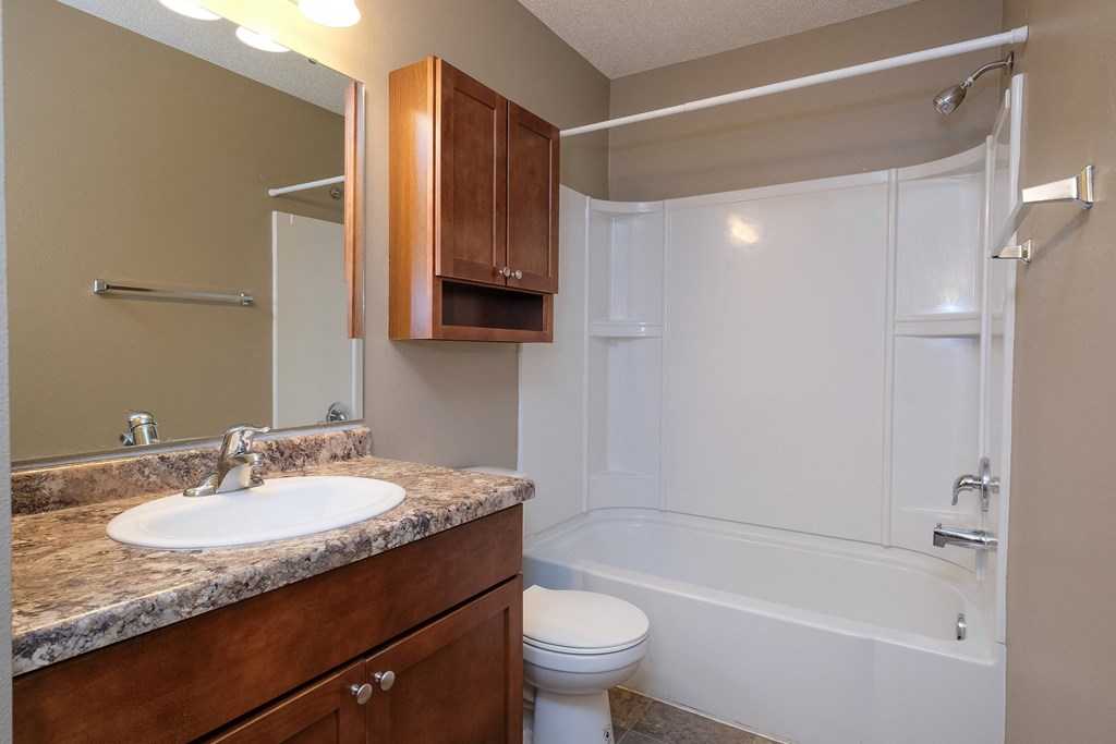 a bathroom with a sink toilet and bath tub. Fargo, ND Carlton Place Apartments