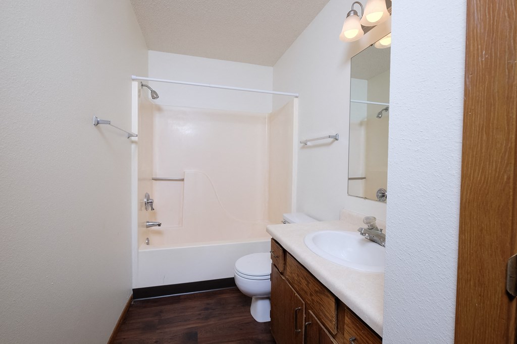 an empty bathroom with a sink toilet and shower. Fargo, ND Carlton Place Apartments