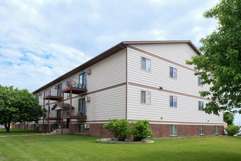 Fargo, ND Carlton Place Apartments | Exterior the exterior of a building with a green lawn and trees. Fargo, ND Carlton Place Apartments