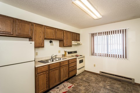 a kitchen with white appliances and wooden cabinets