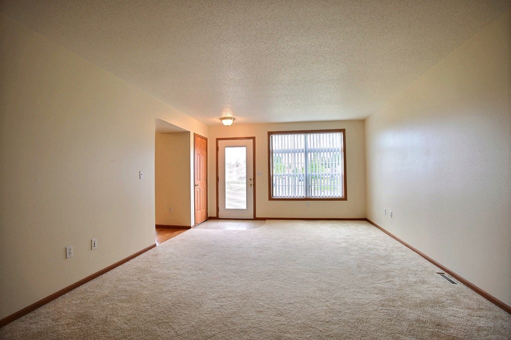 A living room of an empty house with a window