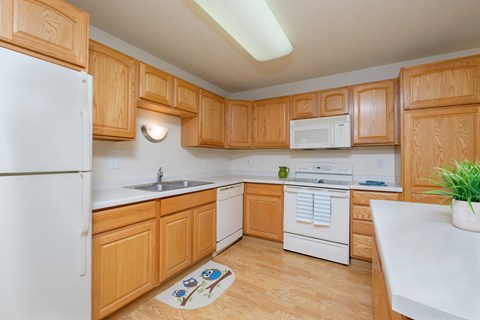 a kitchen with white appliances and wooden cabinets