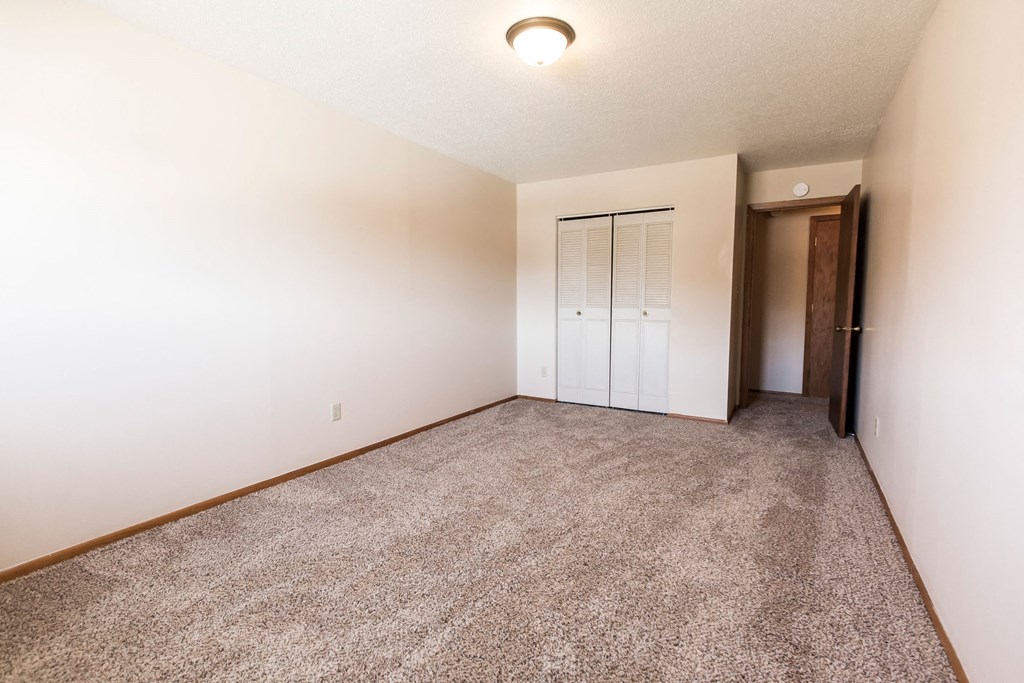 Grand Forks, ND Cherry Creek Apartments. A bedroom with white walls and a carpeted floor