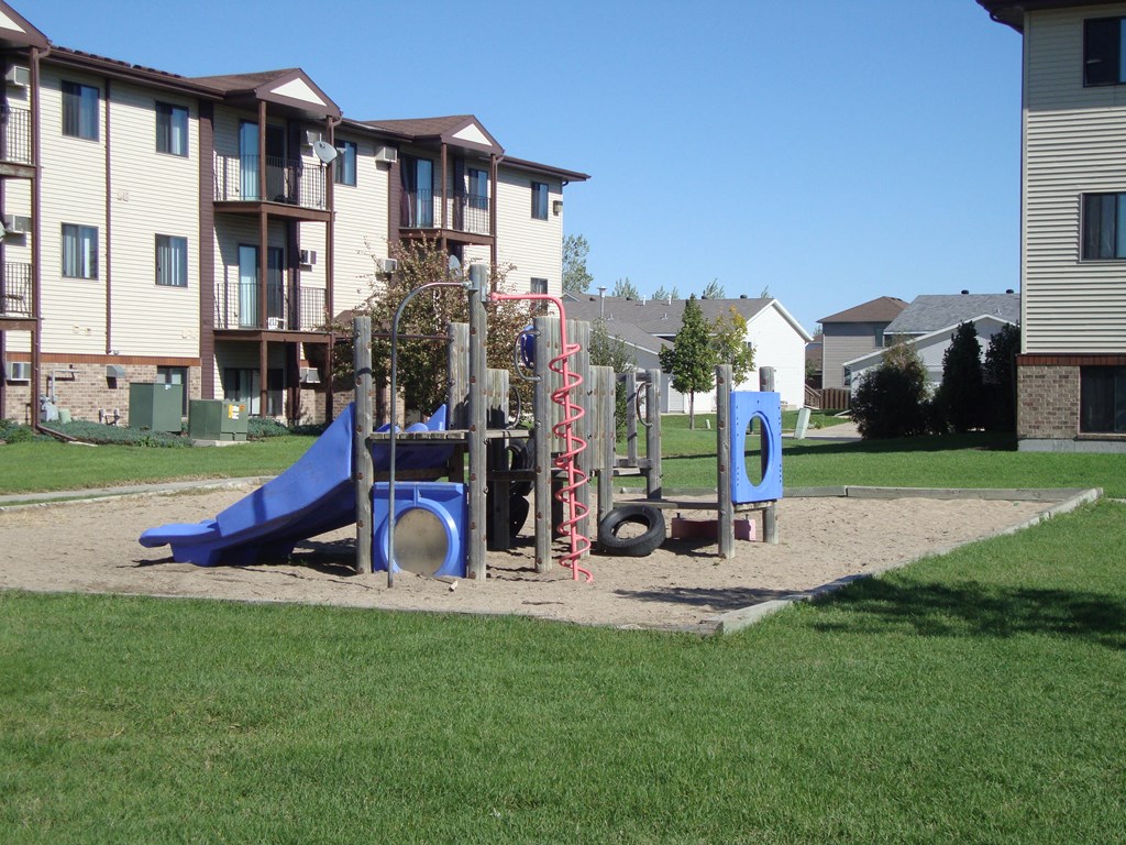 a playground in front of an apartment building. Fargo, ND Chestnut Ridge Apartments