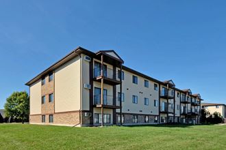 the exterior of an apartment building on a sunny day. Fargo, ND Chestnut Ridge Apartments