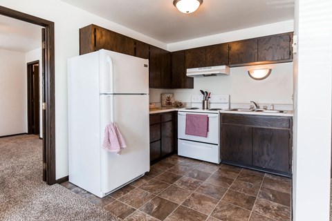 a kitchen with a white refrigerator and a sink