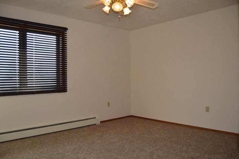 Fargo, ND Clearview Apartments | Bedroom An empty living room with a ceiling fan and a window