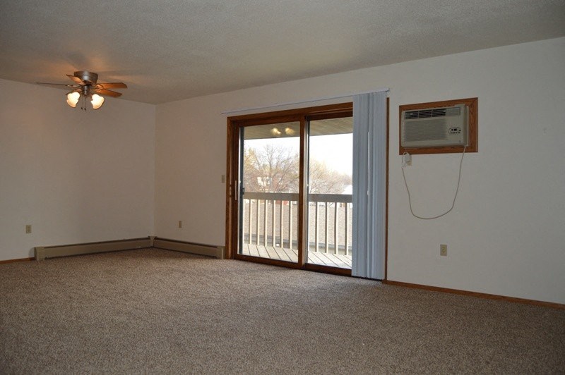 Fargo, ND Clearview Apartments | Living a living room with a carpeted floor and a large window