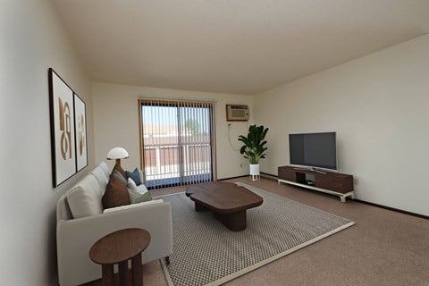 the living room of an apartment with a couch and a tv. Fargo, ND Countryside Apartments