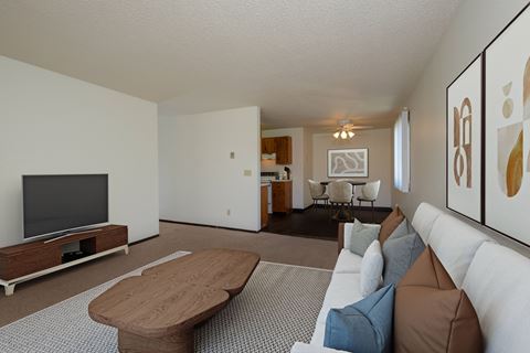 the view of a living room with a couch and a tv. Fargo, ND Countryside Apartments