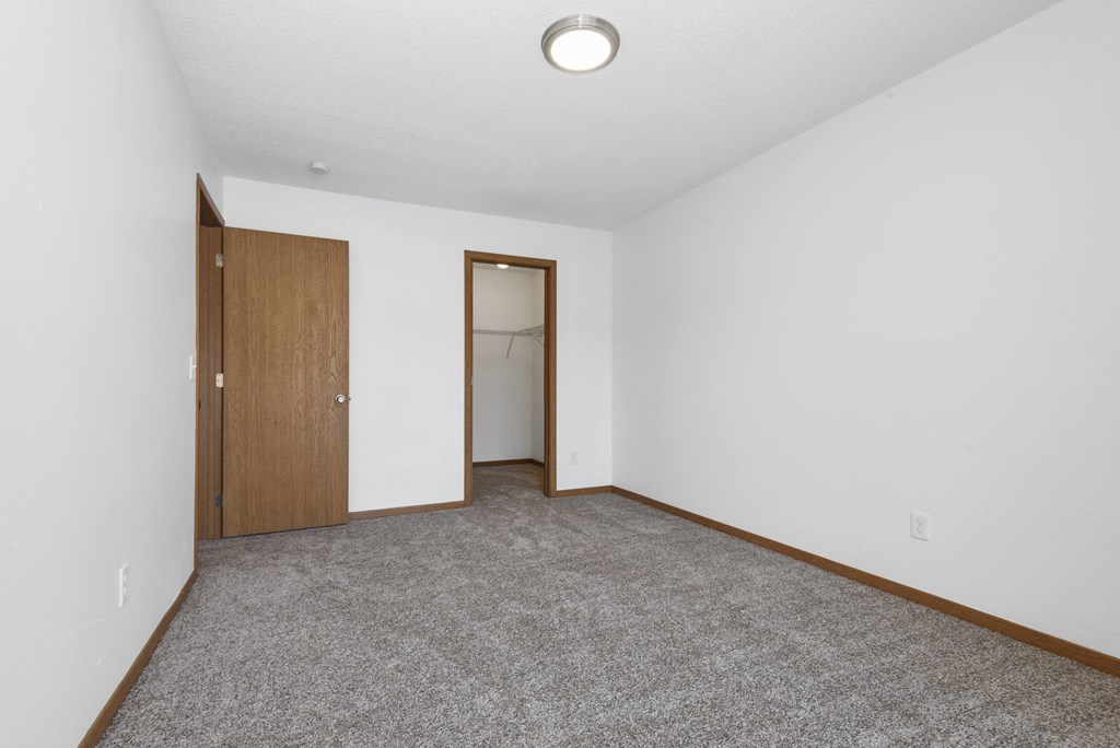 St. Louis Park, MN Courtyard Apartments. A  bedroom with a carpeted floor and a door to a closet