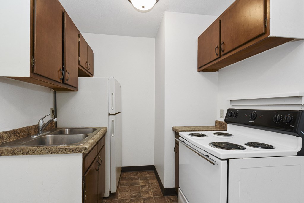 West St. Paul, MN Covington Courts Apartments. a kitchen with white appliances and brown cabinets