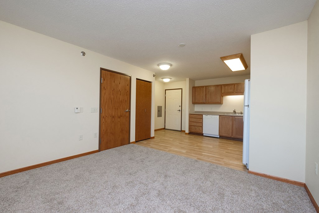 a kitchen with white appliances and wooden cabinets. Fargo, ND Crossroads Apartments