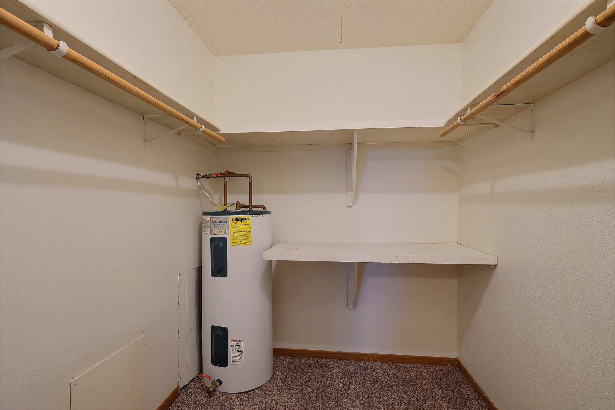 a closet with shelves and a water heater. Fargo, ND Dakota Manor Apartments