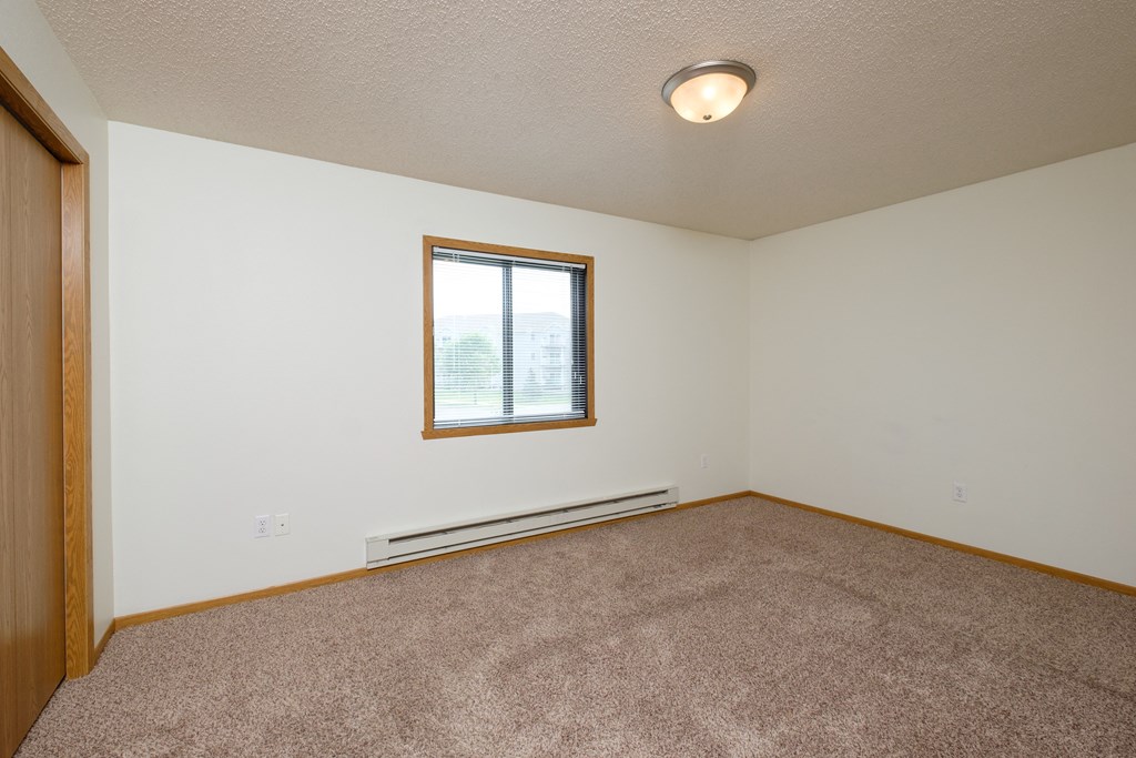 a bedroom with carpet and a window
