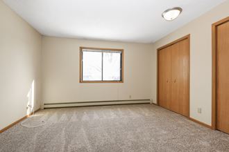 Anoka, MN Dellwood Estates Apartments. A bedroom with a window and a closet - Photo Gallery 5
