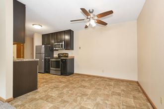 Anoka, MN Dellwood Estates Apartments. A kitchen and living room with a ceiling fan - Photo Gallery 3