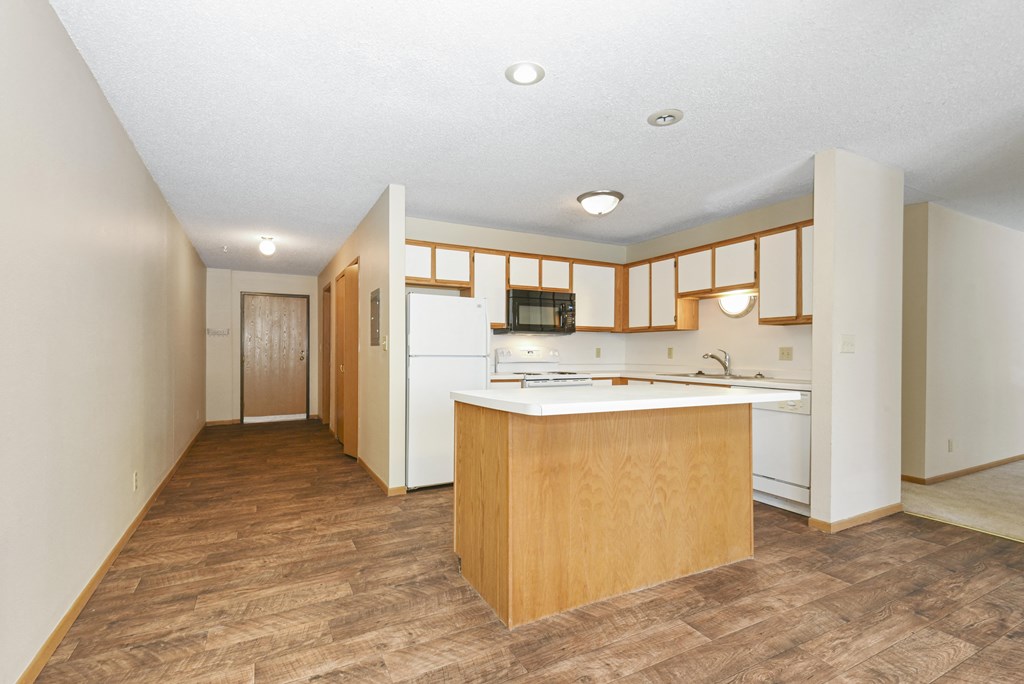 Anoka, MN Dellwood Estates Apartments. a kitchen with white appliances and wooden cabinets
