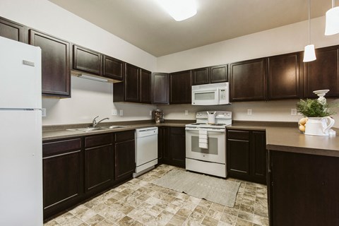 a kitchen with dark wood cabinets and white appliances