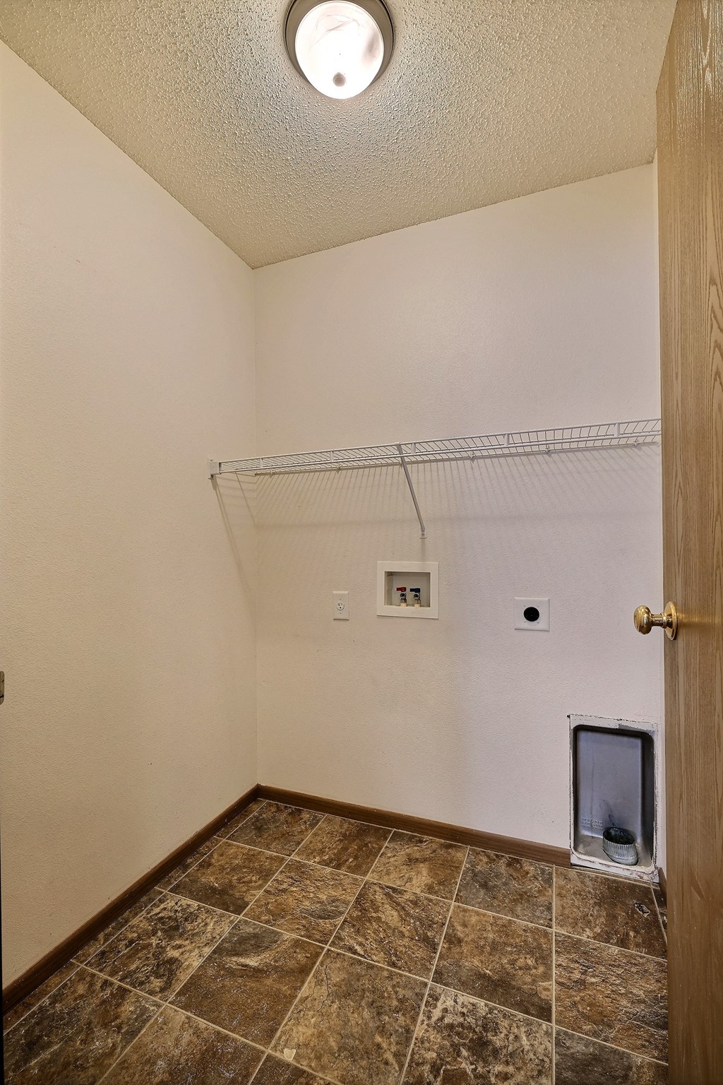 A closet with washer and dryer hookups in the corner. Fargo, ND Eagle Run Apartments.