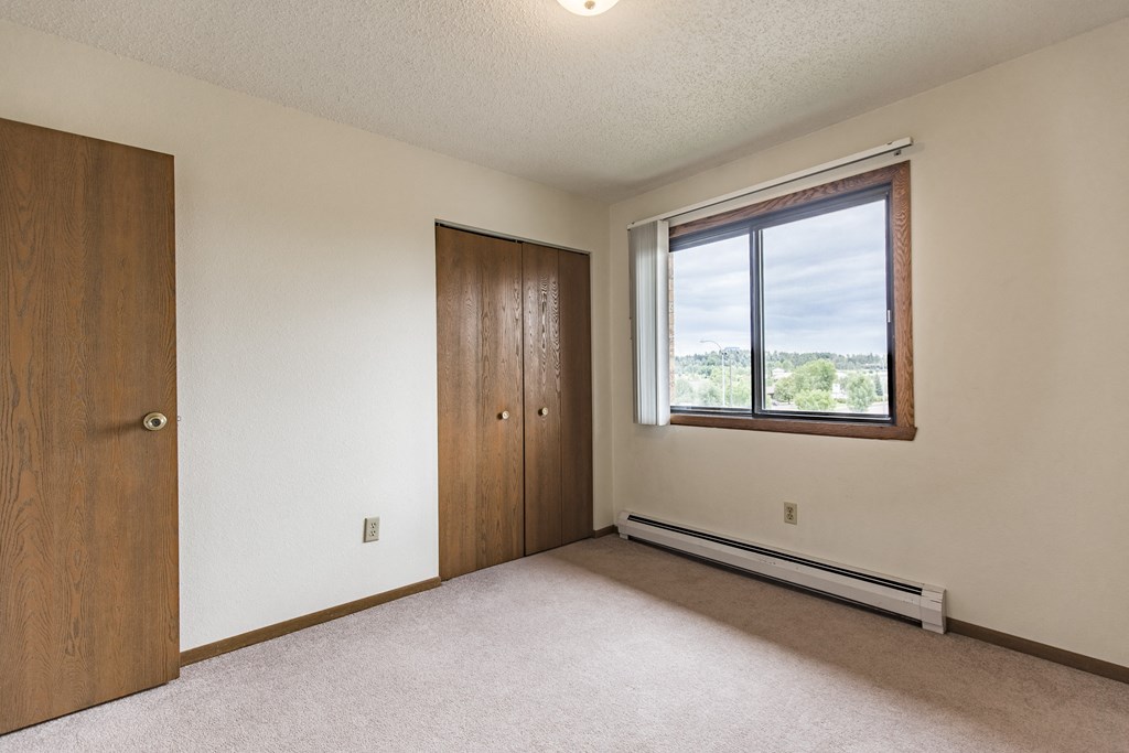 Bismarck, ND Eagle Sky I Apartments. A bedroom with a window and a door