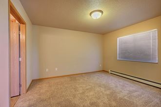 the upstairs bedroom has a large window and carpeted floor. Fargo, ND East Bridge Apartments