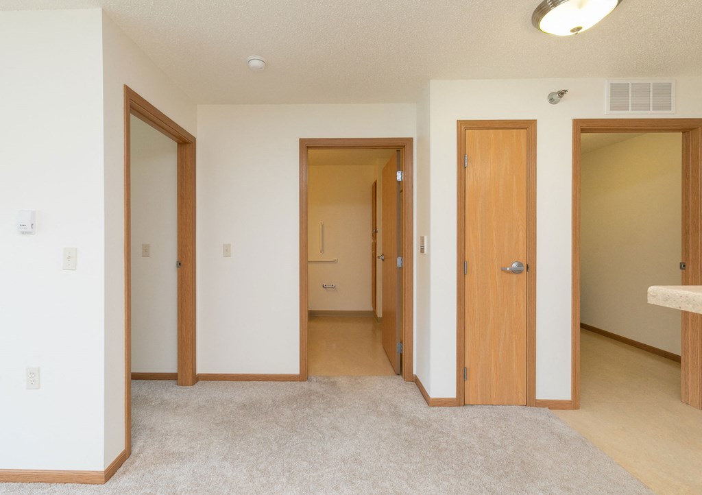 a hallway with doors to bedrooms and bathrooms with a closet. Fargo, ND Sunrise North