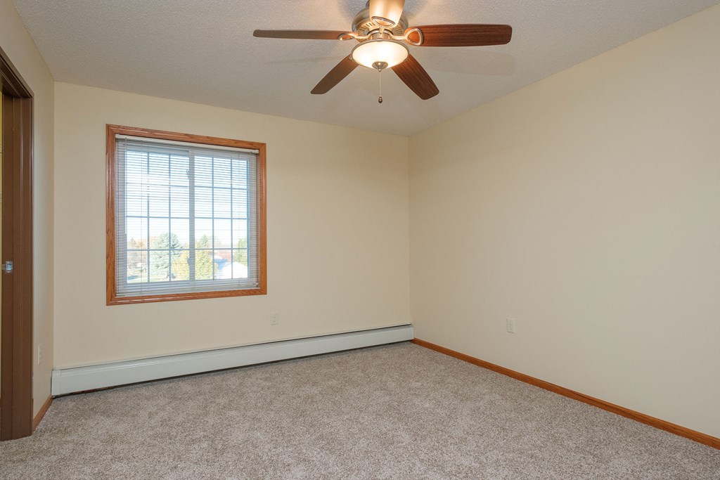 a bedroom with a window. Fargo, ND Crossroads Apartments