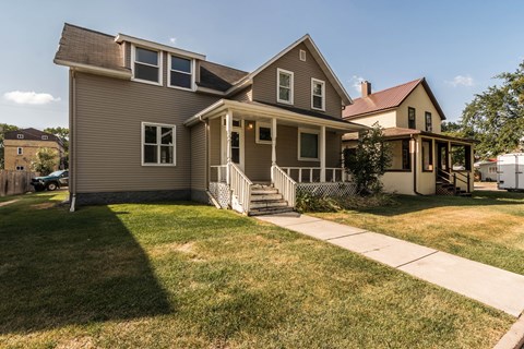 Grand Forks, ND Faul 4 Plex | Exterior Grand Forks, ND Faul 4 Plex. A home with a green lawn and a brown house in the background
