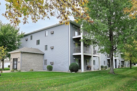 An exterior of a three level apartment with a large grass area out front. Fargo, ND Flagstone Apartments.