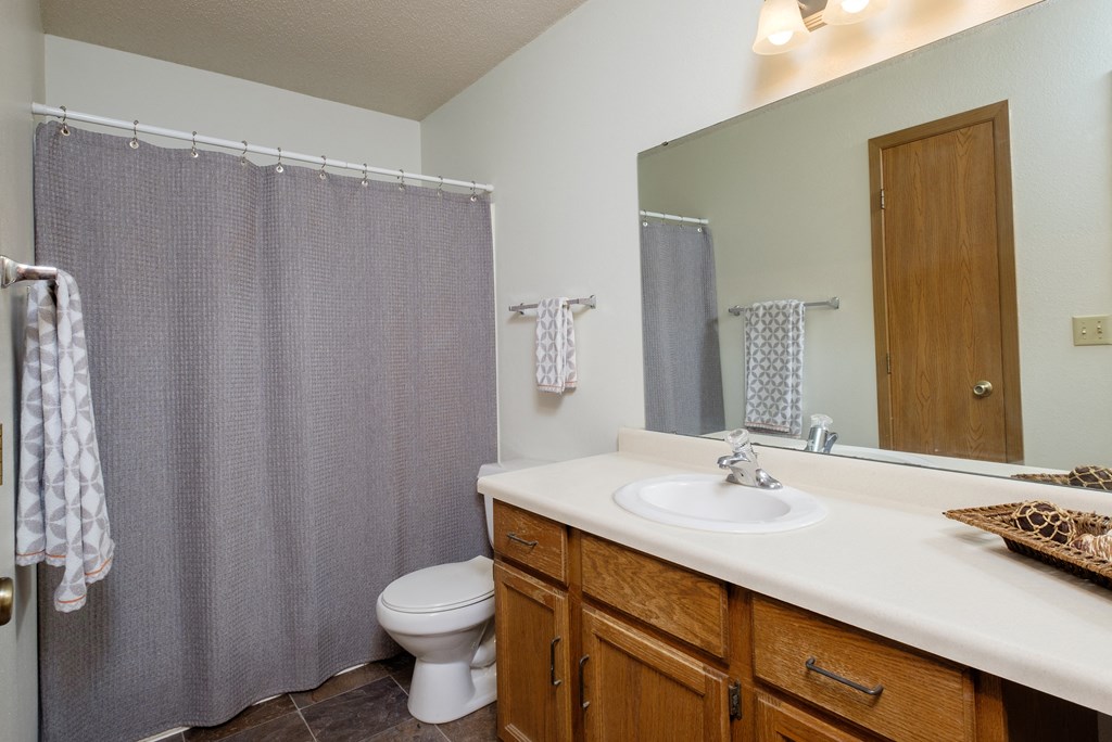 a bathroom with a shower and a sink and a toilet. Fargo, ND Flickertail Apartments