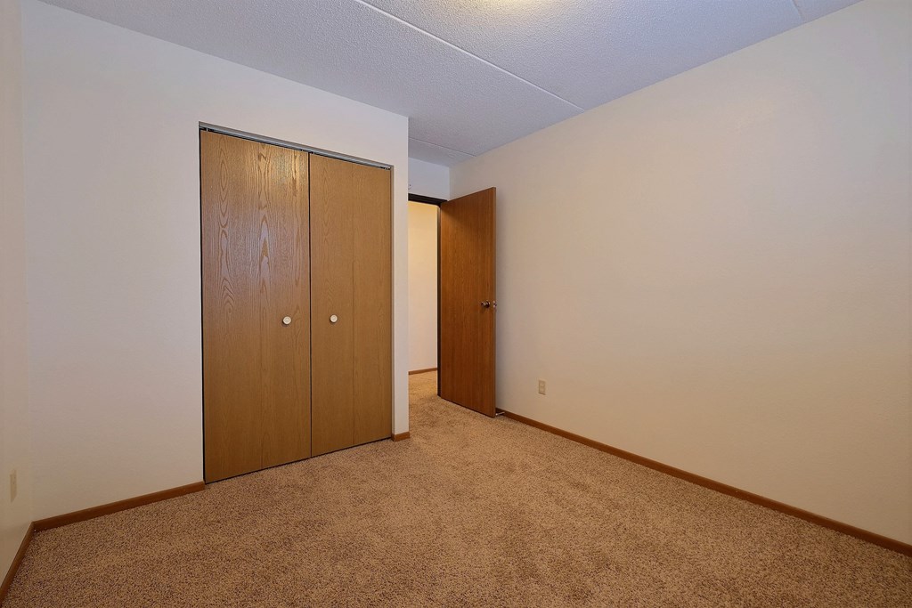 a bedroom with a closet and a door to a hallway at France, Fargo, 58103