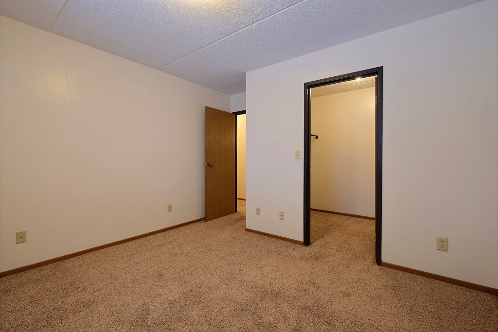 a bedroom with a door to a closet and a carpeted floor at France, Fargo
