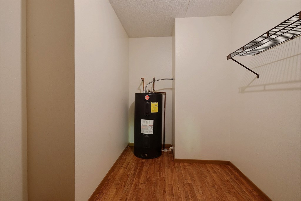 a heater in the corner of a room with a wood floor and a white wall at France, Fargo North Dakota