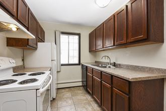 Fridley, MN Georgetown Apartments. A kitchen with brown cabinets and white appliances
