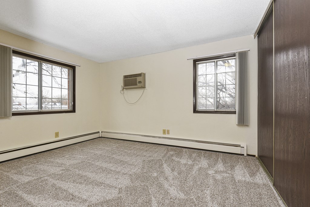 Fridley, MN Georgetown Apartments. A bedroom with two windows and a carpeted floor