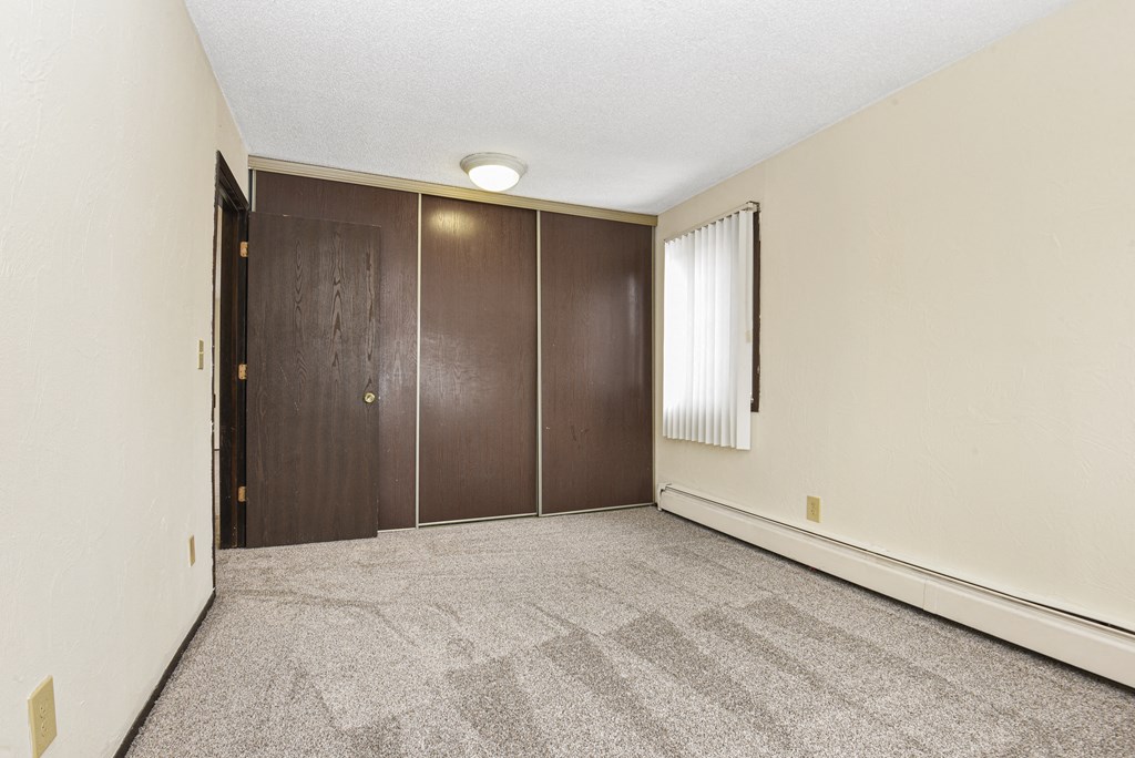 Fridley, MN Georgetown Apartments. A bedroom with two doors and a carpeted floor