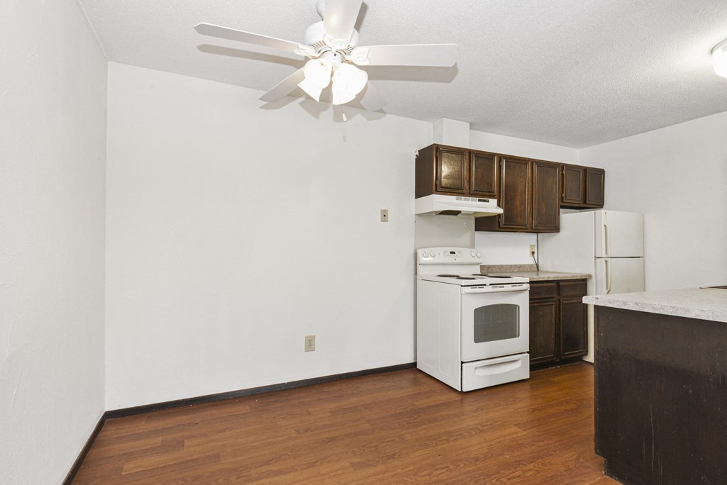 Fridley, MN Georgetown Apartments. A kitchen with white appliances and wooden cabinets