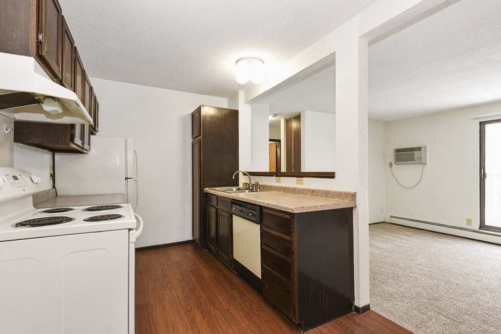 Fridley, MN Georgetown Apartments. A kitchen with white appliances and a wooden floor