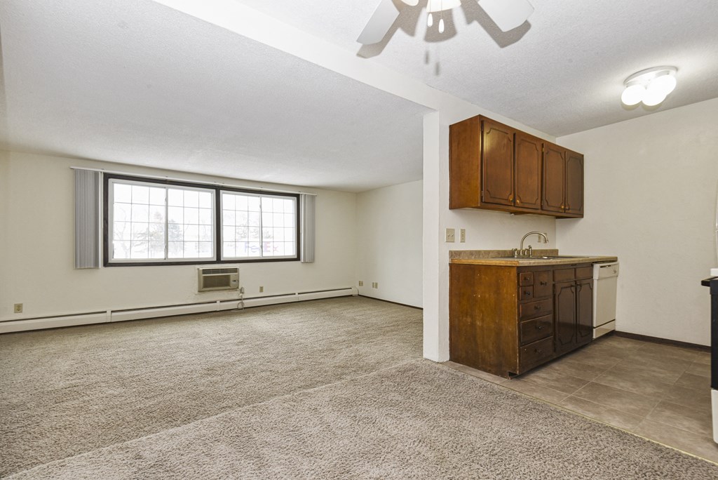 a  living room with a kitchen and a window. Fridley, MN Georgetown on the River Apartments