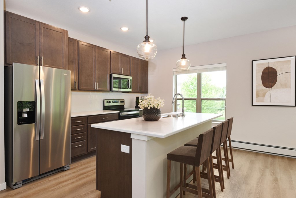 a kitchen with wooden cabinets and a large island with a white countertop