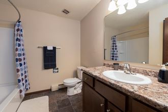 Bismarck, ND Highland Meadows Apartments. A bathroom with a sink toilet and bathtub