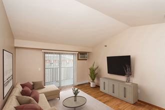 Grand Forks, ND Sterling Pointe Apartments. a living room with a couch and a tv on the wall - Photo Gallery 3