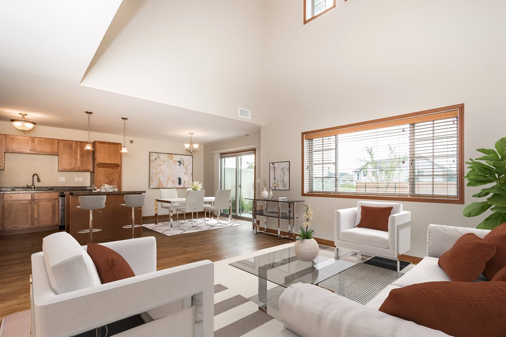Grand Forks, ND Sterling Pointe Apartments. a living room with white couches and chairs and a glass coffee table