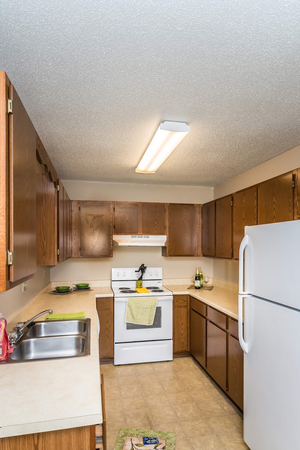 Grand Forks, ND Grandview I Apartments. a kitchen with white appliances and wooden cabinets