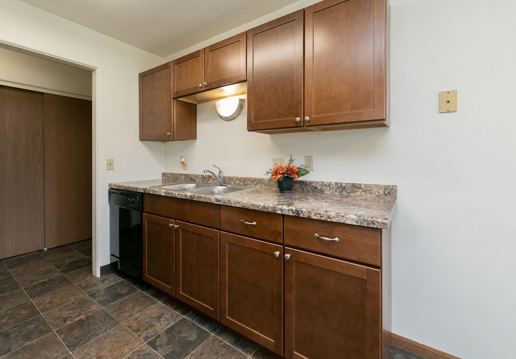a kitchen with wooden cabinets and granite counter tops