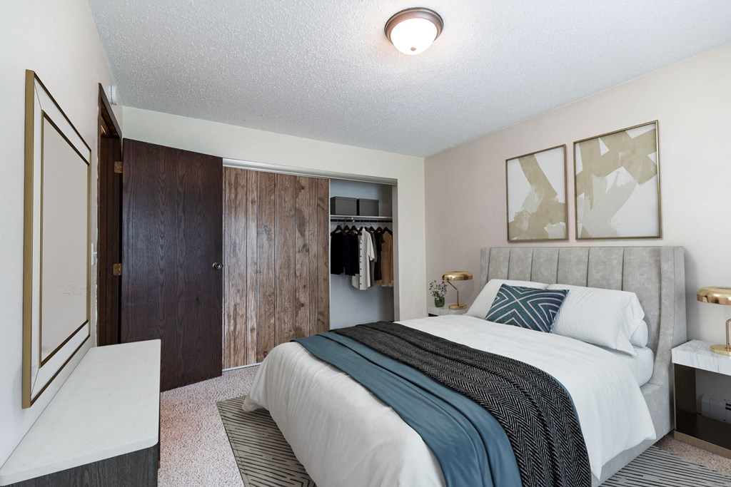 a bedroom with a bed and a closet. Bismarck, ND Hannifin Apartments
