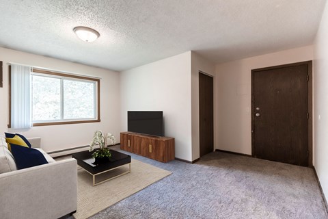 an empty living room with a couch and a television