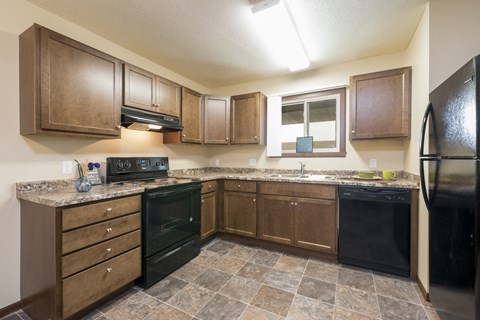 a kitchen with black appliances and wooden cabinets