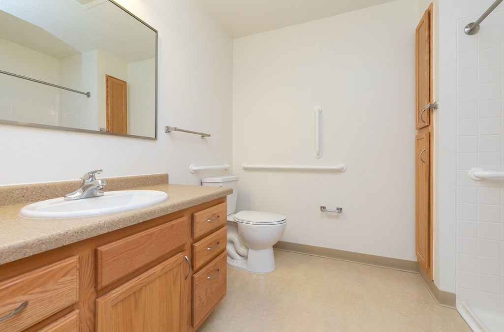 a bathroom with a sink and a toilet and a shower. Fargo, ND Sunrise North